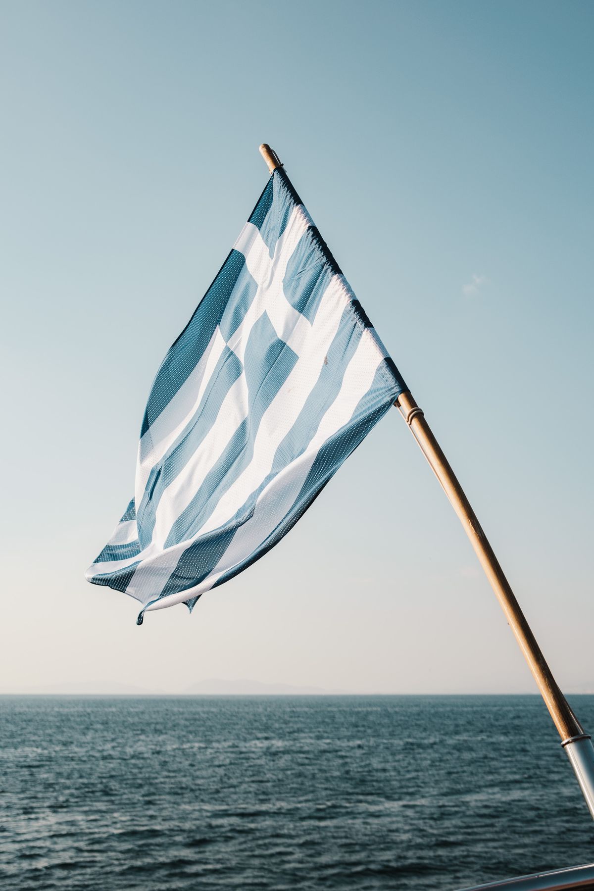 Ελληνική σημαία σε ιστό με φόντο τον ουρανό και τη θάλασσα. Ενδεικτική φωτογραφία για την ελληνική διπλωματική αντίδραση.