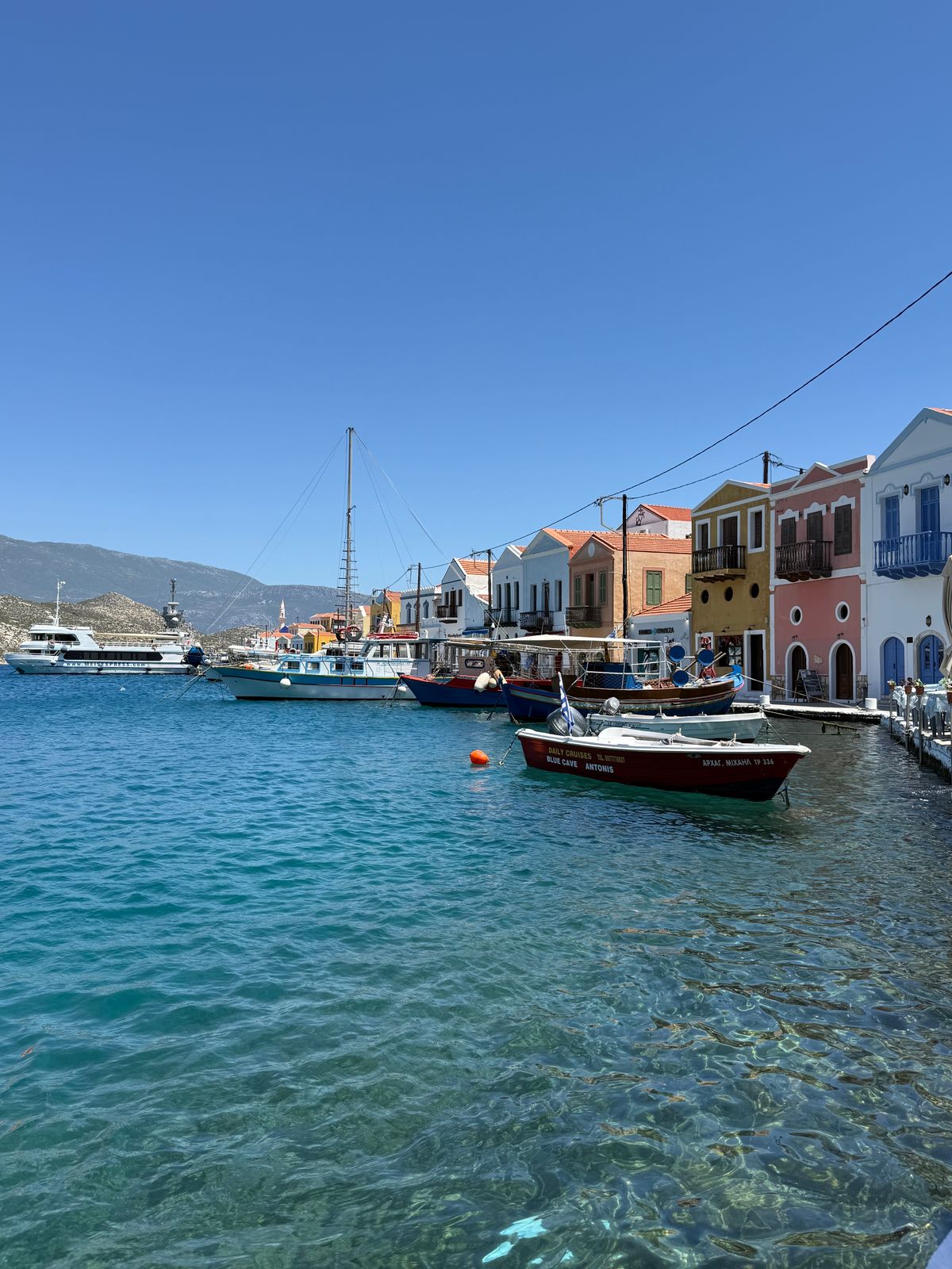 Πολύχρωμα κτίρια και βάρκες στο λιμάνι του Καστελλόριζου — ενδεικτική εικόνα του τόπου, όχι από την περιοδεία.
