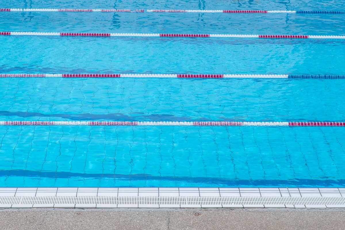 Γαλάζιο νερό σε άδεια πισίνα με διαχωριστικά διαδρομών· ενδεικτική εικόνα υγρού στίβου, όχι επιβεβαιωμένος χώρος του Παγκοσμίου 2029.