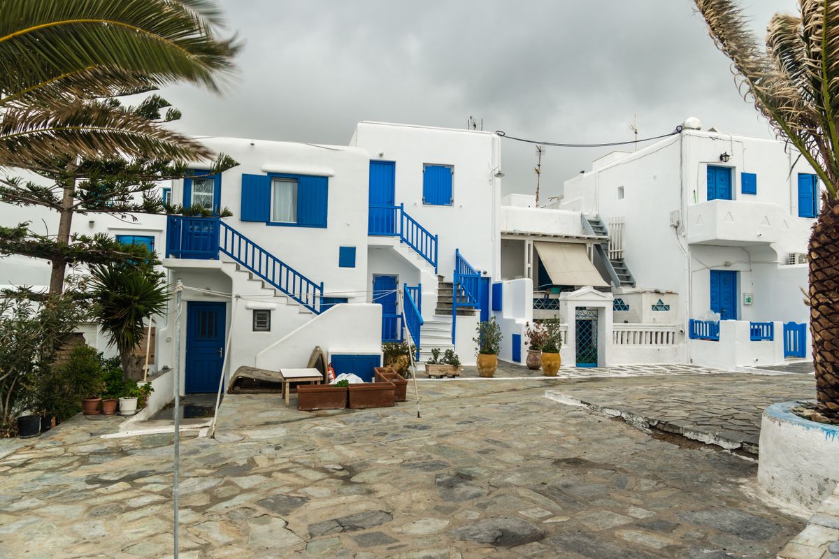 Λευκά και γαλάζια σπίτια με πέτρινα μονοπάτια σε ελληνικό χωριό — ενδεικτική φωτογραφία, χωρίς ταυτοποίηση φορολογικών δικαιούχων